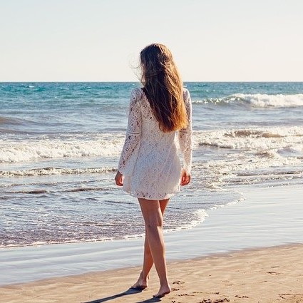 Photo of a woman on the beach with her back to the camera
